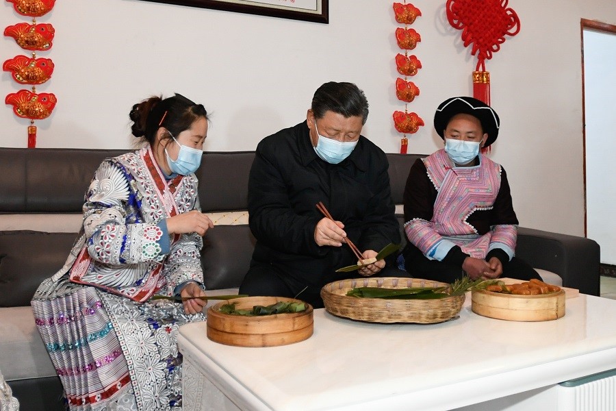 2021年2月3日下午，習(xí)近平在貴州畢節(jié)市黔西縣新仁苗族鄉(xiāng)化屋村苗族村民趙玉學(xué)家，同一家人邊聊家常邊制作當(dāng)?shù)貍鹘y(tǒng)節(jié)日食品黃粑。新華社記者 李學(xué)仁 攝